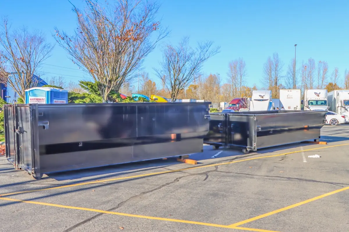 Professional dumpster rental service with roll-off container on residential driveway in Woburn